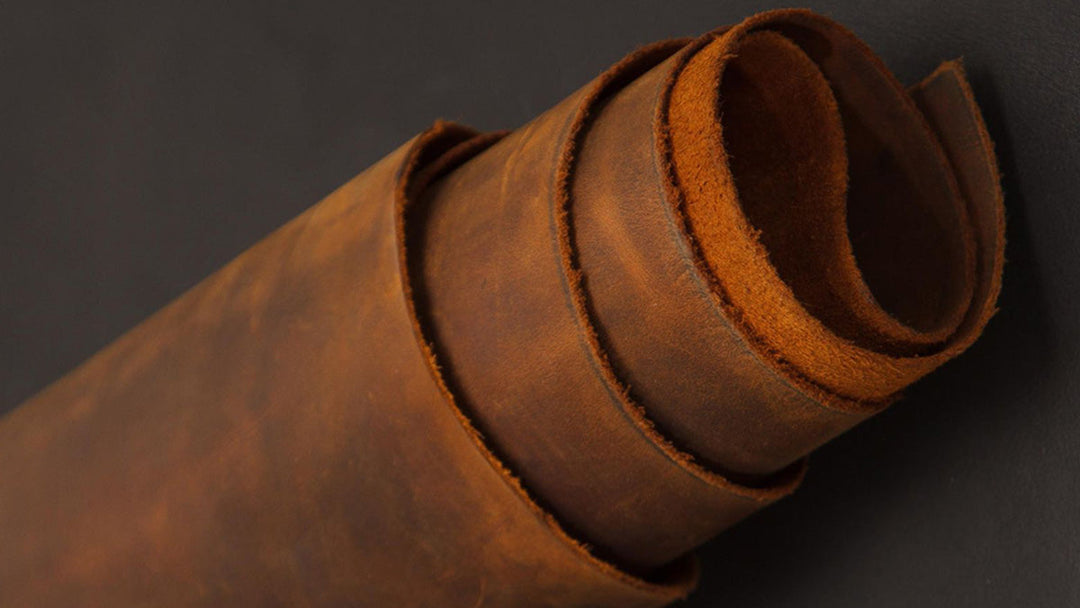 Close-up of rolled natural full grain leather showing raw surface texture and grain density.