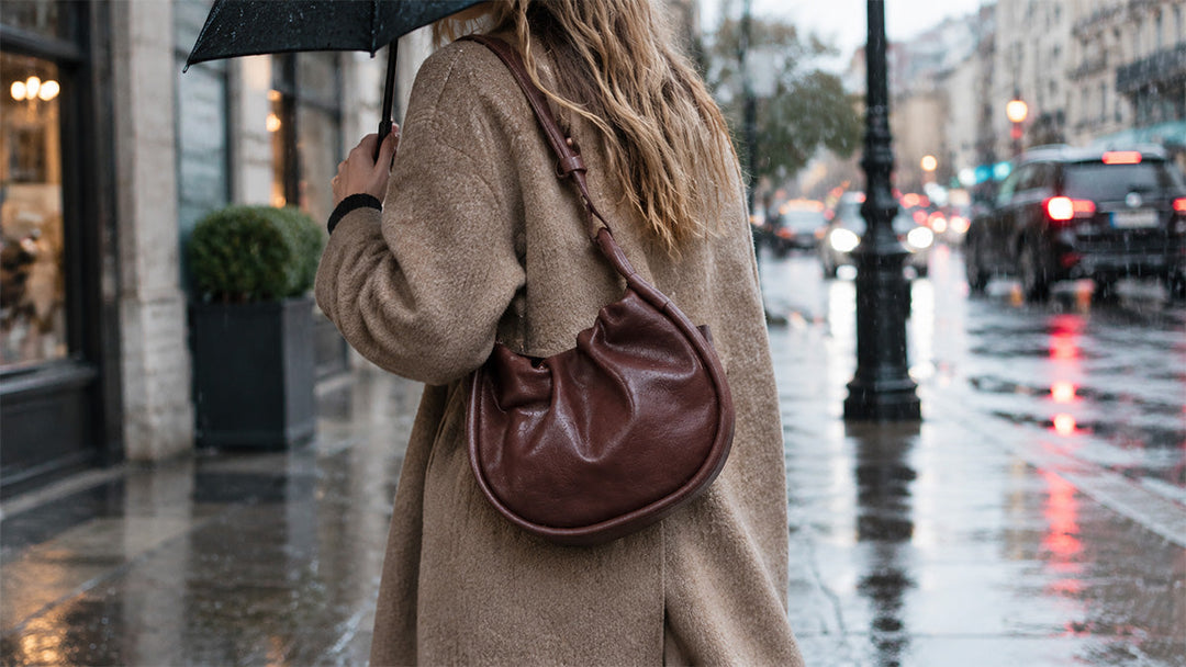 woman carrying a leather bag outdoors during a rainy day