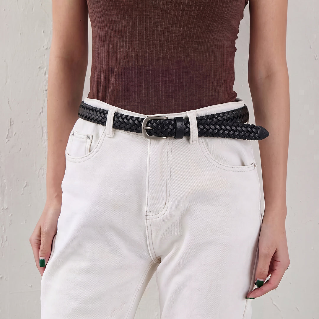 Woman wearing a black braided leather belt with white high-waisted trousers.
