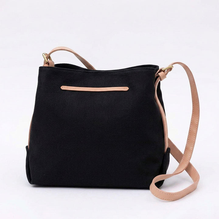 Black canvas crossbody purse with tan leather shoulder strap.