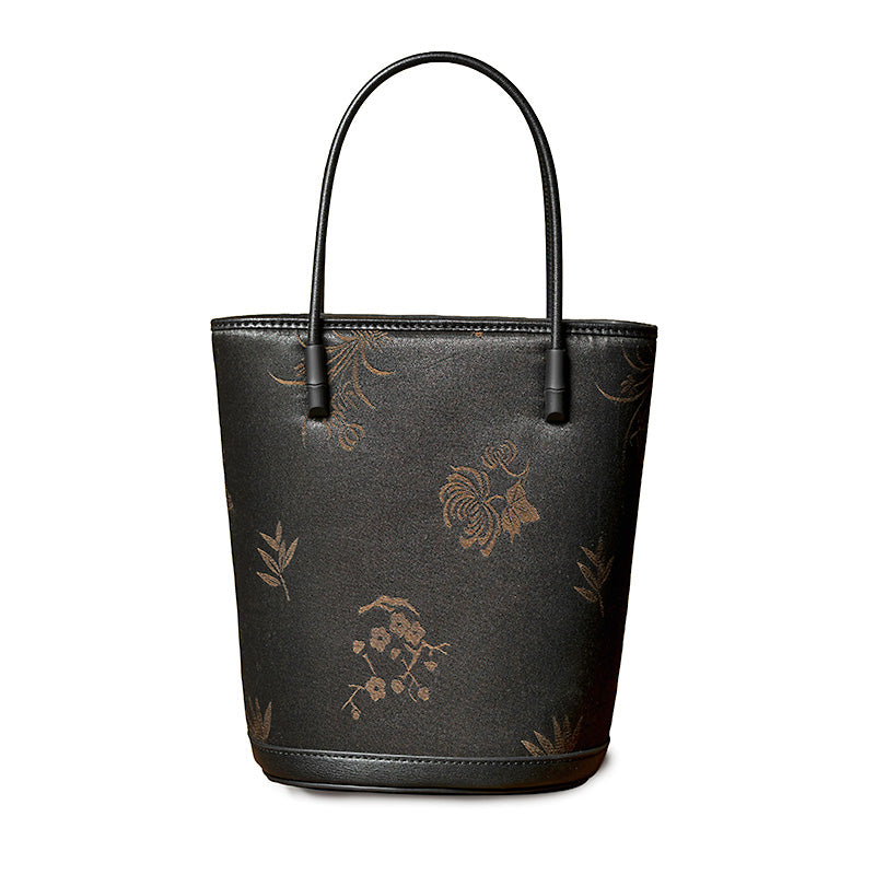 Black Xiangyunsha mulberry silk and leather bucket bag with adjustable crossbody strap, handcrafted in China.