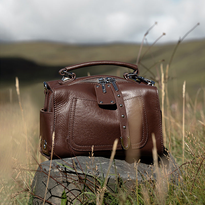 Brown vegetable tanned leather Boston bag with metal studs and dual detachable shoulder straps