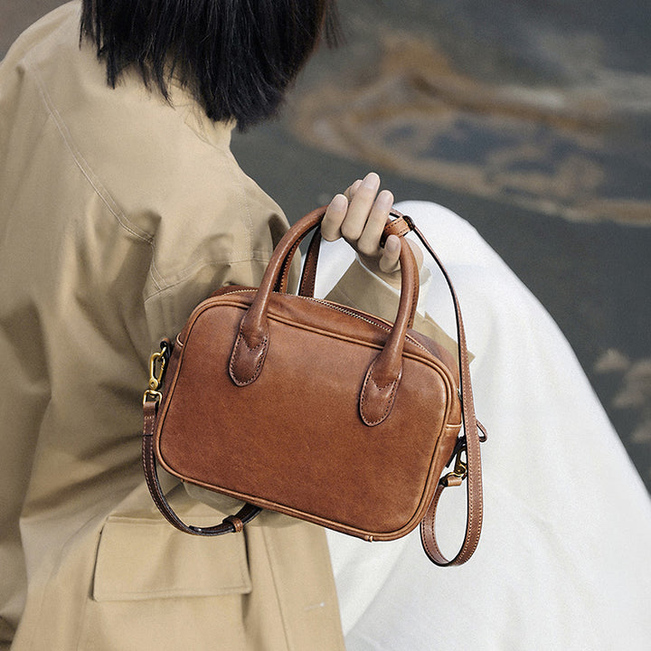 Brown vegetable tanned leather Boston bag with top handle, gold hardware and detachable strap