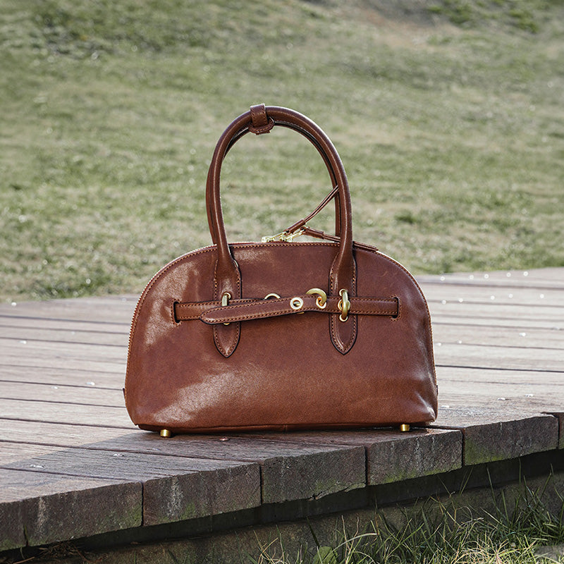 Brown vegetable tanned leather Boston bag with dual top handles and detachable shoulder strap