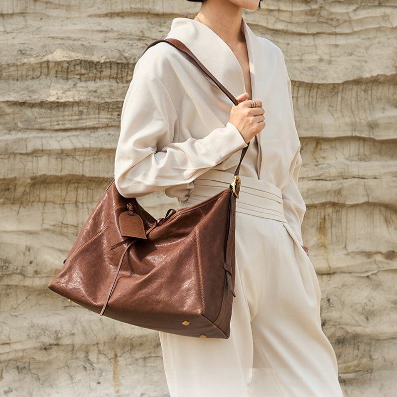 Brown vegetable tanned leather tote bag with top handle and adjustable shoulder strap