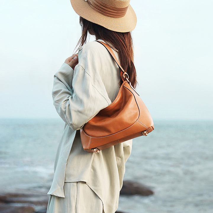 Camel vegetable tanned leather hobo tote bag with dual shoulder straps and metal base feet