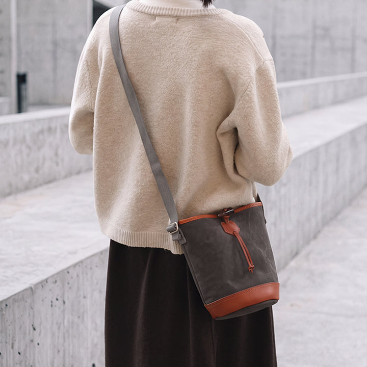 Gray canvas bucket bag with leather trim worn crossbody