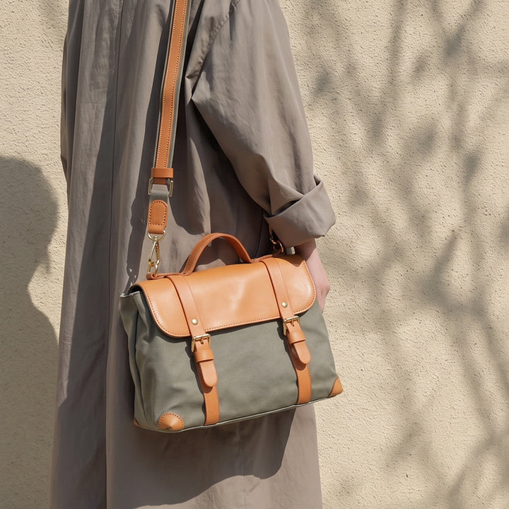 Sage green canvas messenger bag with leather flap worn crossbody, vintage style