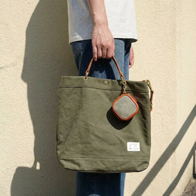 Army green canvas tote bag with leather handles and small coin pouch, handheld carry