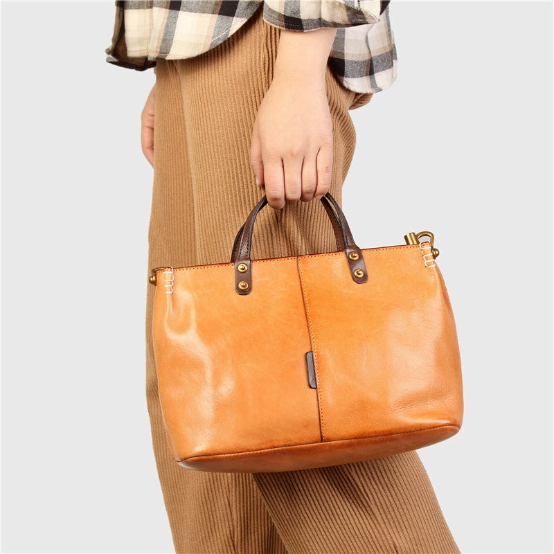 Woman carrying a color block full-grain leather handbag in warm yellow brown