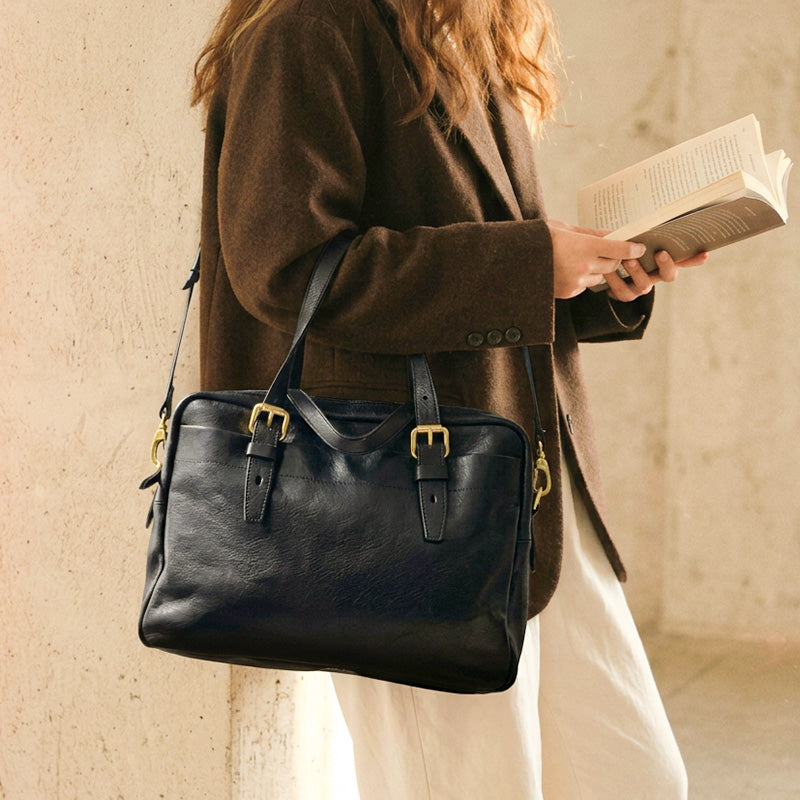 Compact black leather briefcase with gold hardware and front pocket, a lightweight convertible shoulder bag for work.