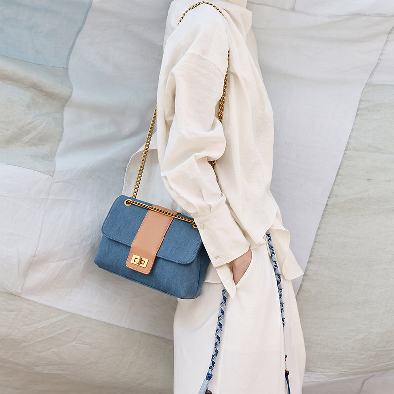 Denim flap bag with gold chain strap worn crossbody