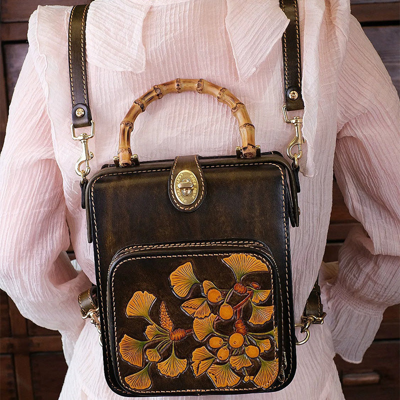 Woman wearing a mini leather backpack with a bamboo handle and hand-tooled ginkgo leaves.