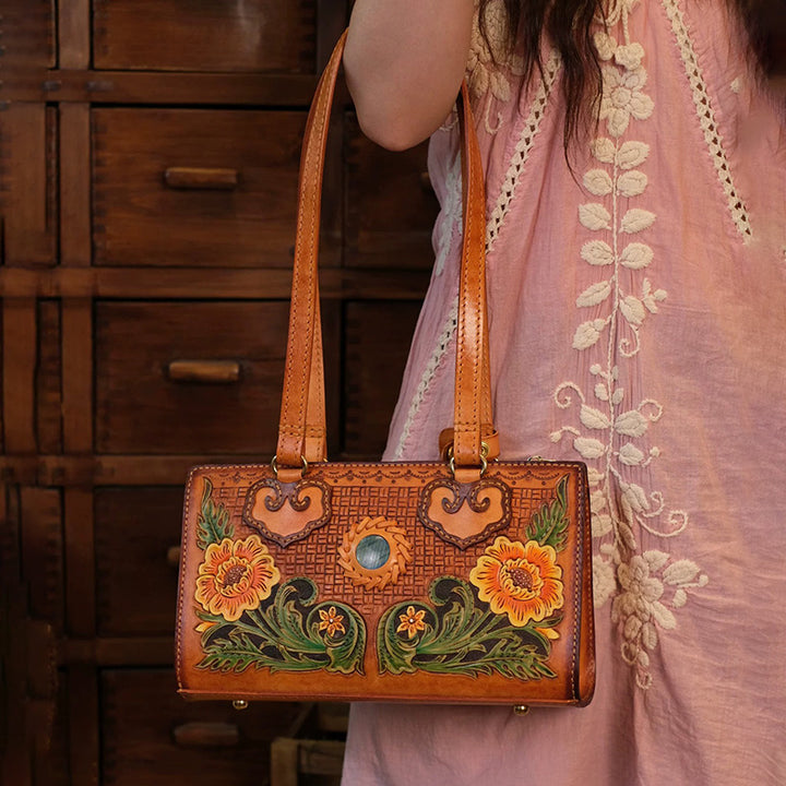 Hand-carved leather box bag with sunflower artwork, worn on shoulder