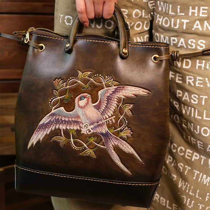 Hand-tooled leather bucket bag with an embossed flying bird design