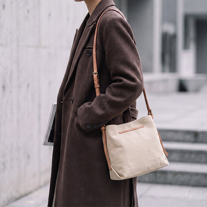 Woman wearing Khaki canvas crossbody purse outdoors.