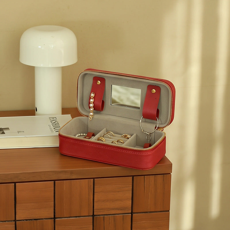 Large vegetable tanned leather travel jewelry box with carry handle and brass snap buttons, open view showing bracelet bar and mirror.