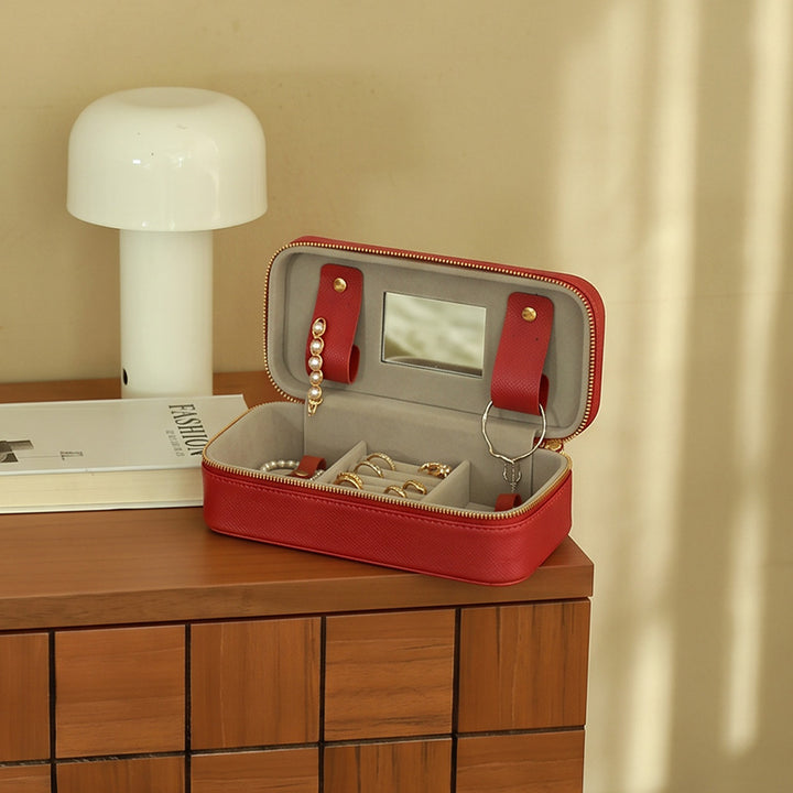 Large vegetable tanned leather travel jewelry box with carry handle and brass snap buttons, open view showing bracelet bar and mirror.