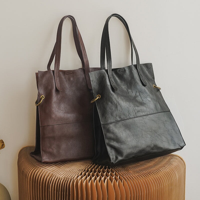 Two large leather tote bags in black and coffee, showing convertible shoulder carry