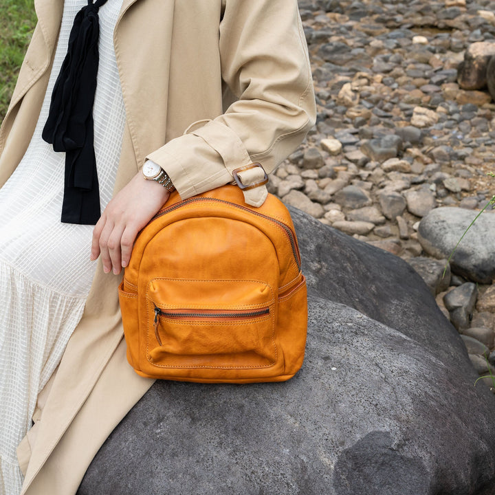 Woman carrying a small vegetable tanned wax leather backpack in sunset yellow