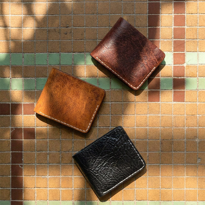 Slim handmade vegetable tanned leather bifold wallet, showing clean unlined interior.