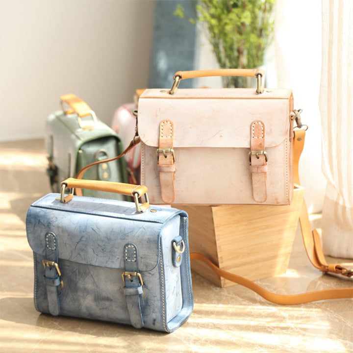 Small leather Cambridge satchel bags in blue and yellow displayed side by side