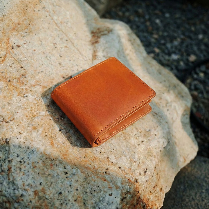 Slim vegetable tanned leather card holder in yellow with clear ID window and contrast hand-stitching.