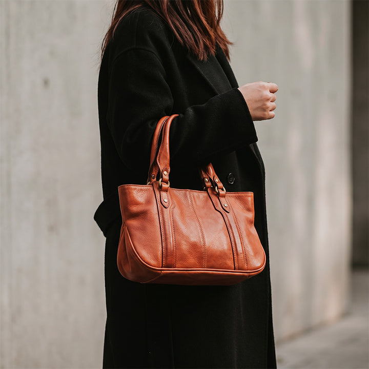 Structured vegetable tanned leather doctor bag with dual top handles and curved base, in honey brown