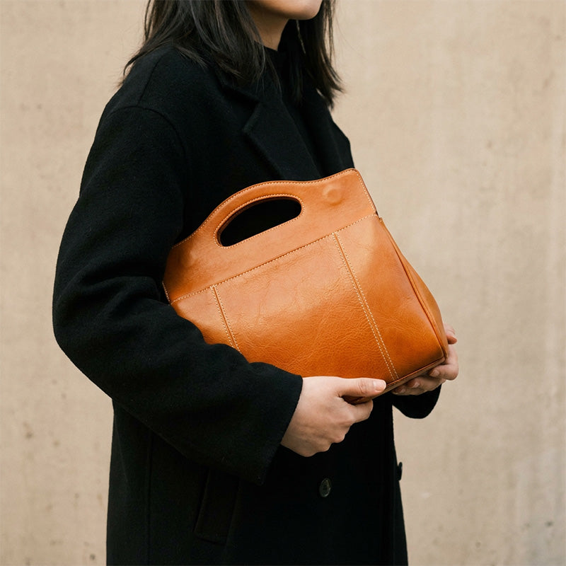 Structured vegetable-tanned leather flap bag with cut-out top handle, in yellow.