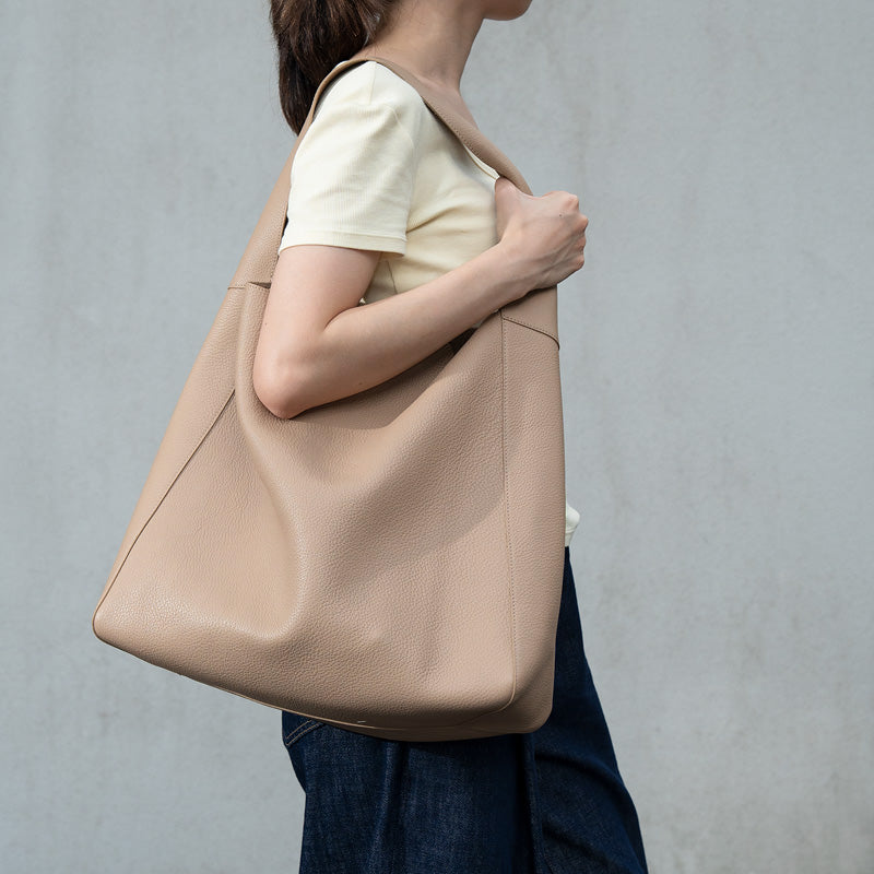 Large beige leather hobo tote bag with soft pebbled texture and single shoulder strap.