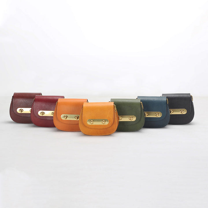 Vegetable tanned leather mini saddle bag with double gold twist-lock clasp and chain strap