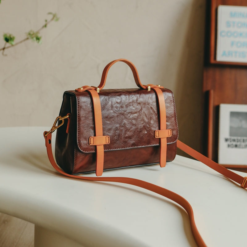 Vintage leather satchel crossbody bag in deep coffee with contrast orange buckle straps and top handle