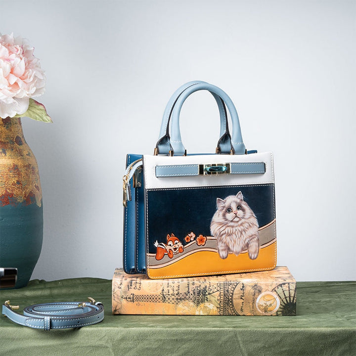 Hand tooled leather top handle bag with carved cat design in blue