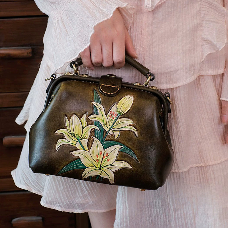 Woman holding a mini leather doctor bag with hand-tooled lilies.