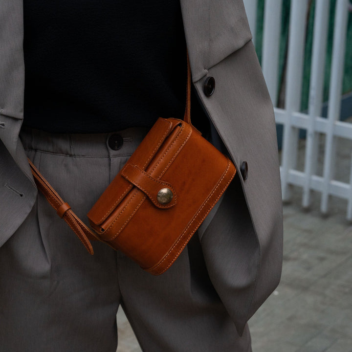 Woman wearing a vintage brown leather mini box crossbody bag with gold clasp