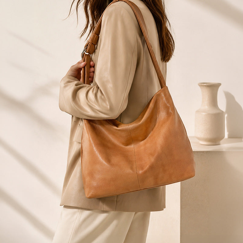 Orange top grain leather hobo bag with slouchy silhouette and adjustable shoulder strap