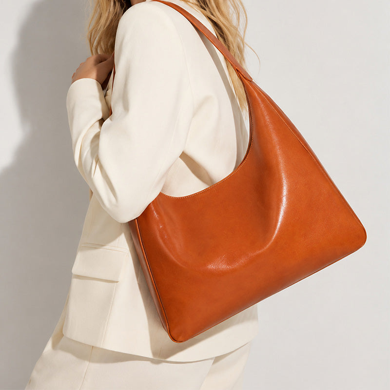 Orange vegetable tanned leather hobo bag with structured silhouette and back zip pocket 