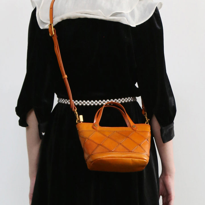 Orange woven leather mini handbag with a top handle and crossbody strap.