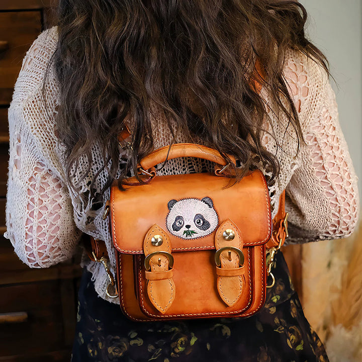 A woman wears a brown leather backpack with a hand-carved panda motif.