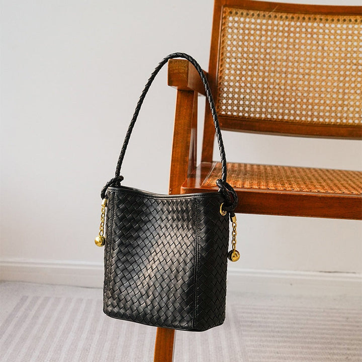 Handwoven sheepskin leather bucket bag in black checkerboard pattern with gold charm