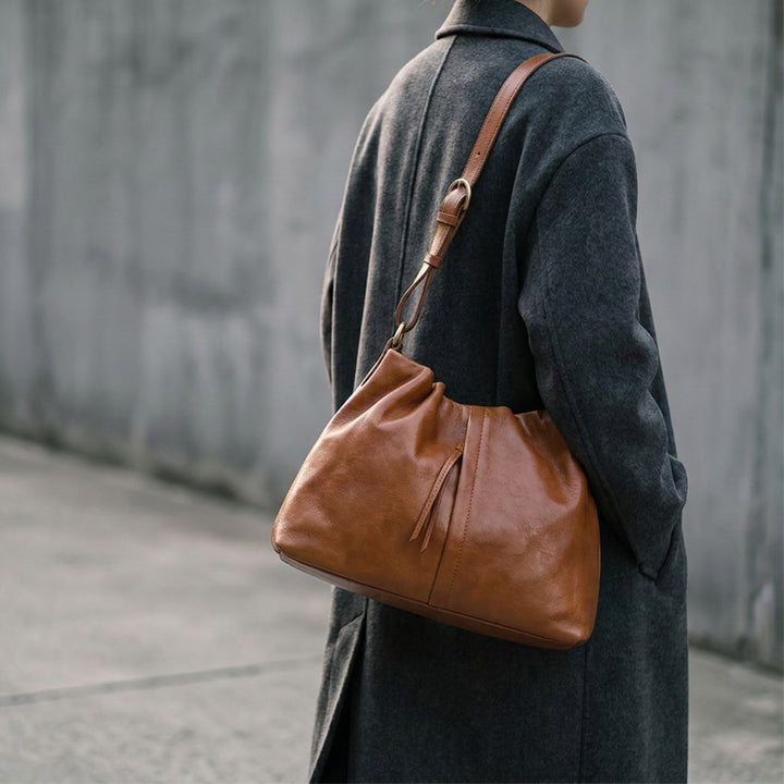 Slouchy ruched vegetable-tanned leather hobo bag in black with gold hardware.