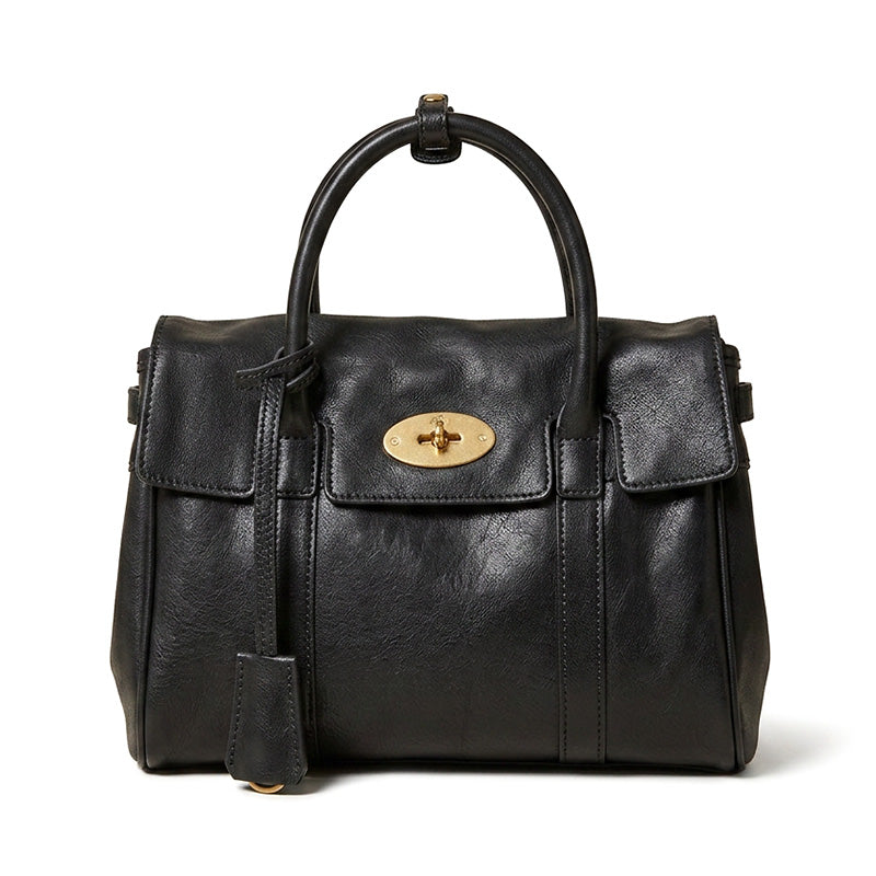 Small vegetable tanned leather satchel bag in black with gold top handle and detachable crossbody strap