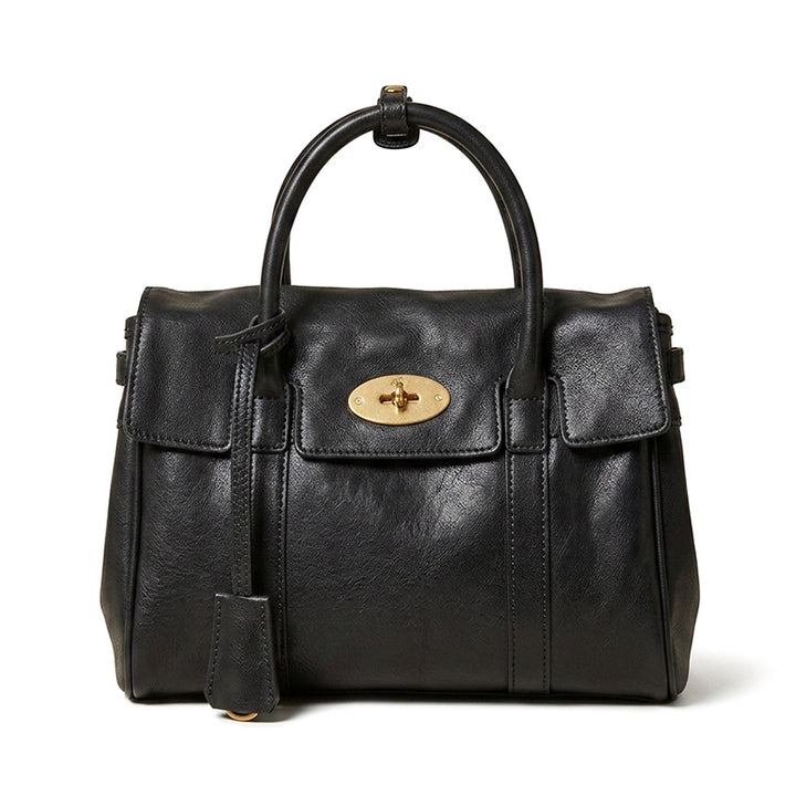 Small vegetable tanned leather satchel bag in black with gold top handle and detachable crossbody strap