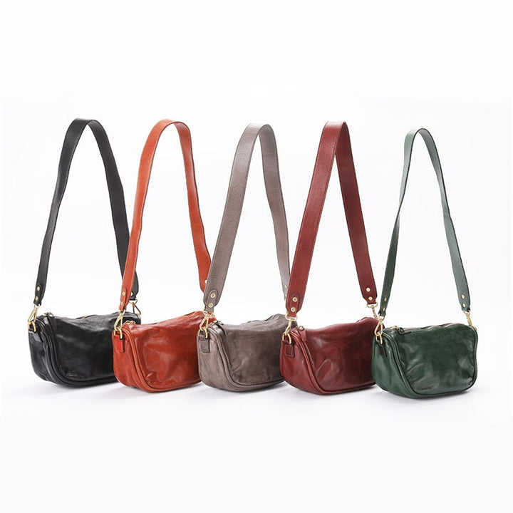 Five soft leather crossbody bags in black, brown, grey, red and green on white background
