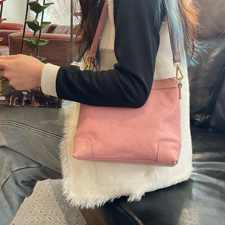 Woman wearing a soft leather shoulder bag in cherry blossom pink shoulder style