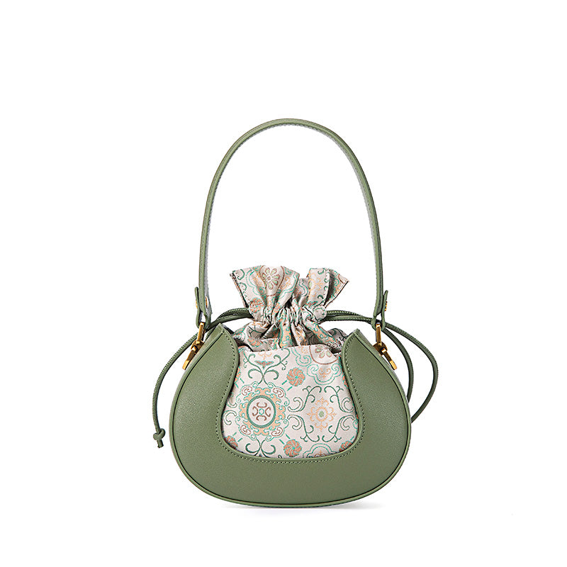 Green Song brocade silk bucket bag with floral pattern and leather trim, shown front view