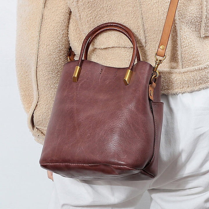 Woman carrying a structured cowhide leather top handle bag in red