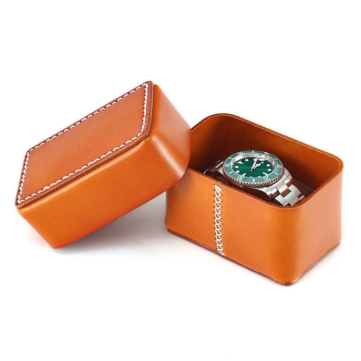 Top grain cowhide leather watch box in honey brown with a watch resting inside the open lid