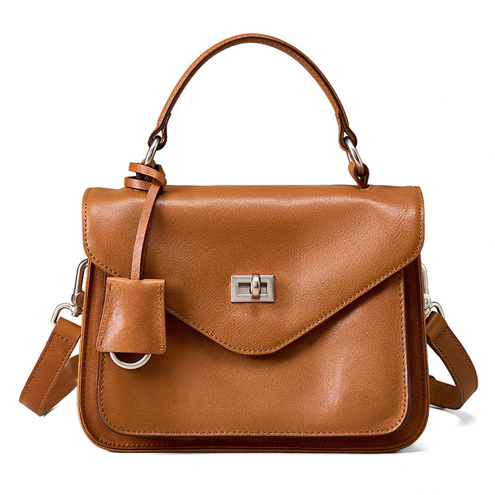 Vegetable tanned leather satchel in camel with gold-plated twist-lock hardware and detachable strap