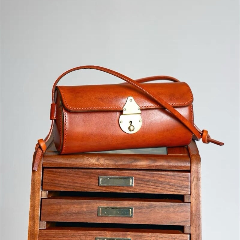 Vegetable tanned leather barrel bag with vintage cylinder silhouette and crossbody strap